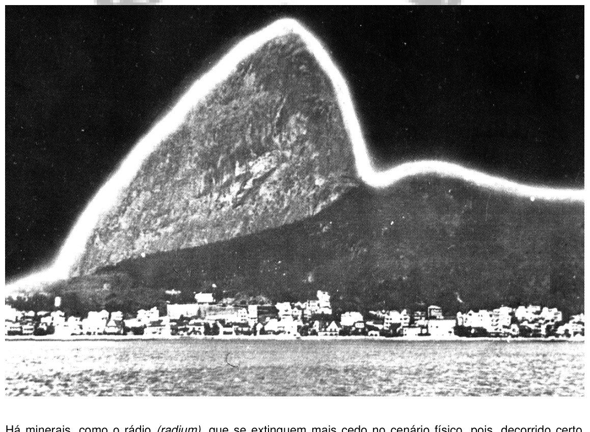 Paisagem noturna de uma montanha costeira envolta por halo luminoso que destaca o seu contorno.
